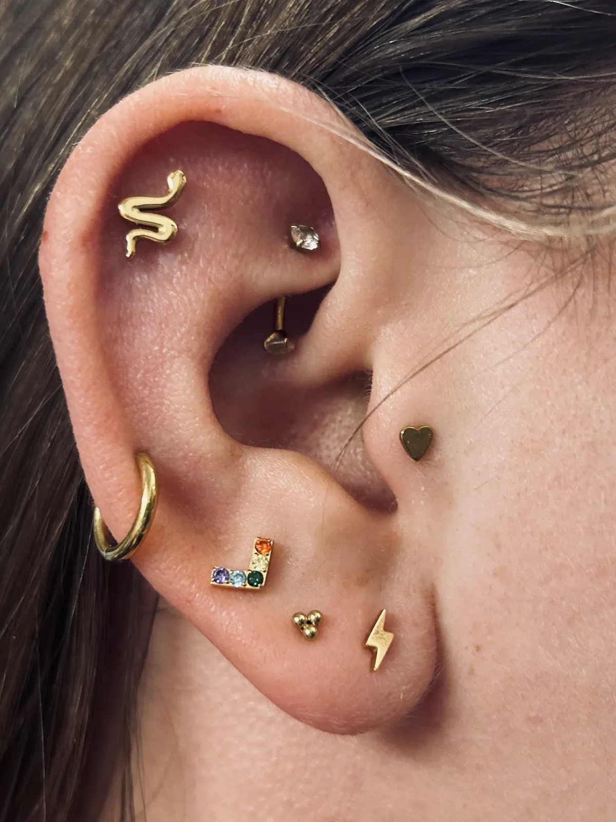 Curated ear with gold and gem jewelry by Sydney