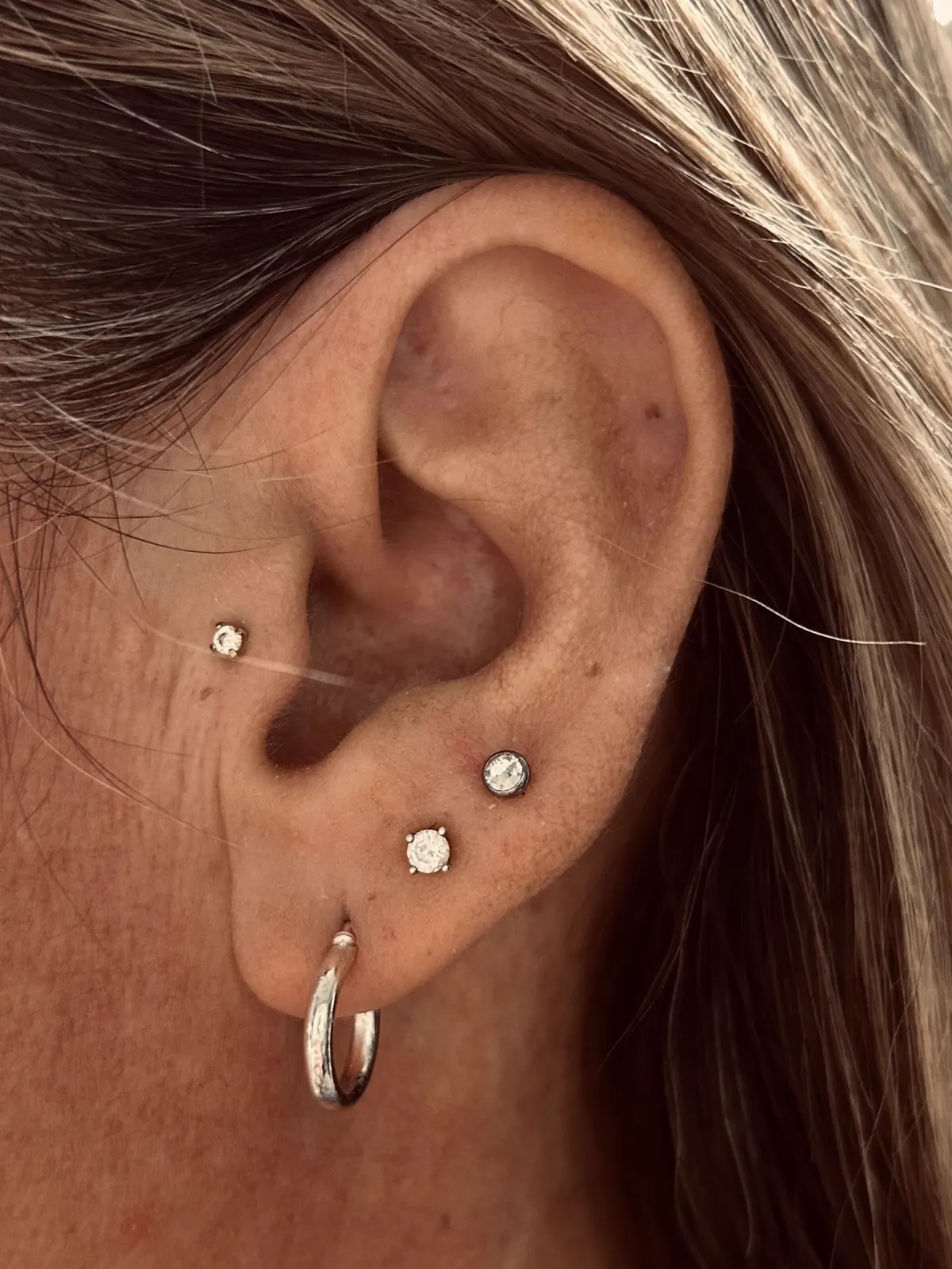 Triple lobe piercings with hoop and studs by Sydney