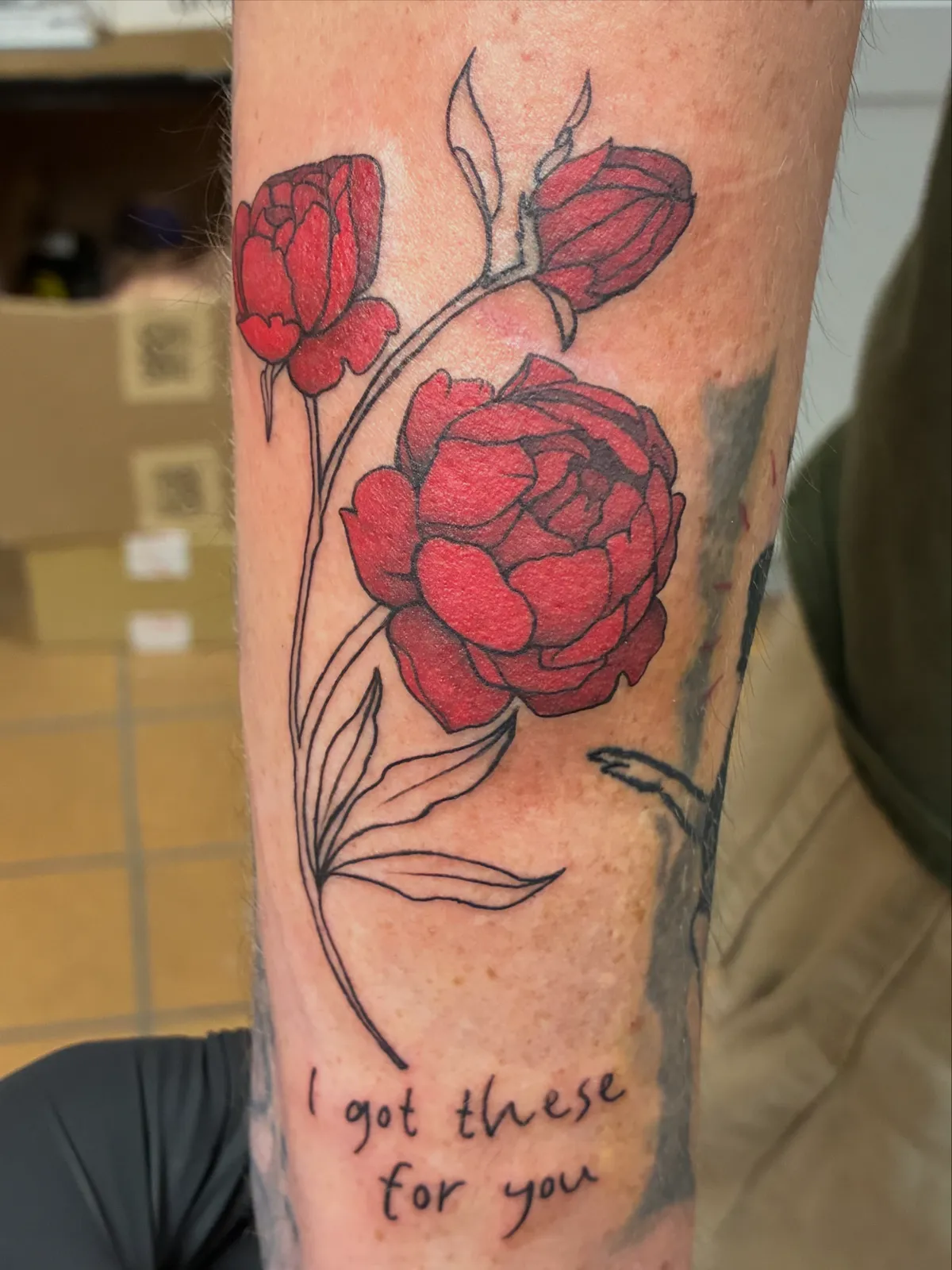 Red roses and script arm tattoo by Sav
