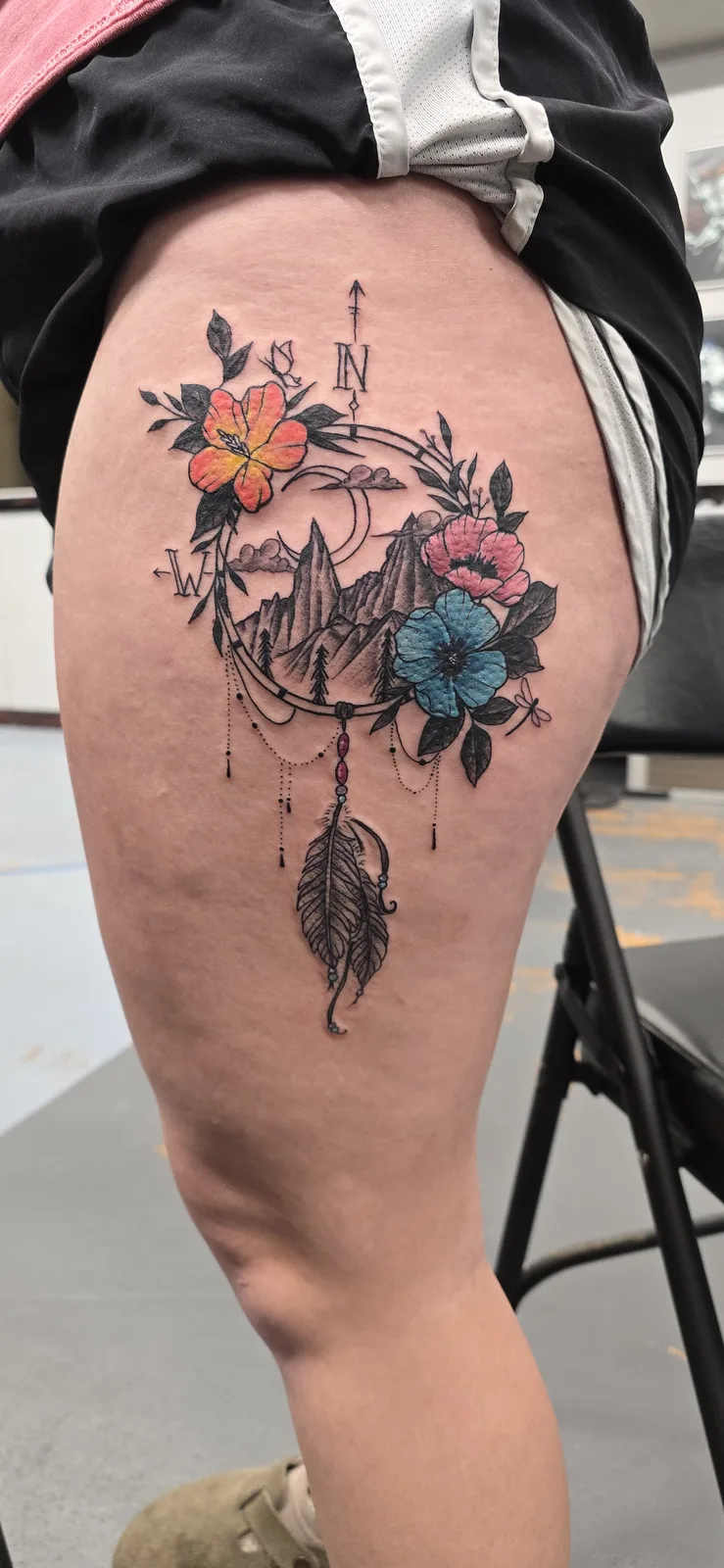 Color floral and arrow thigh tattoo by Joshua Key