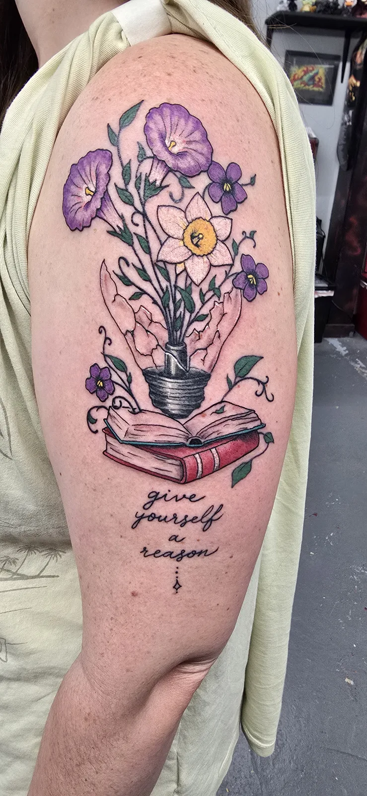 Floral bouquet and book arm tattoo by Joshua Key