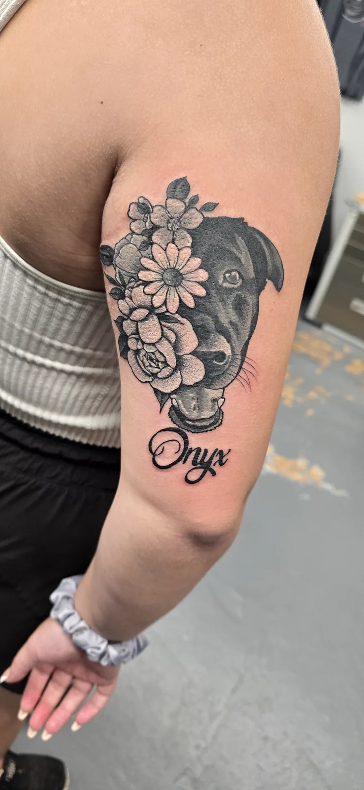 Black and gray floral tattoo on the arm by Joshua Key