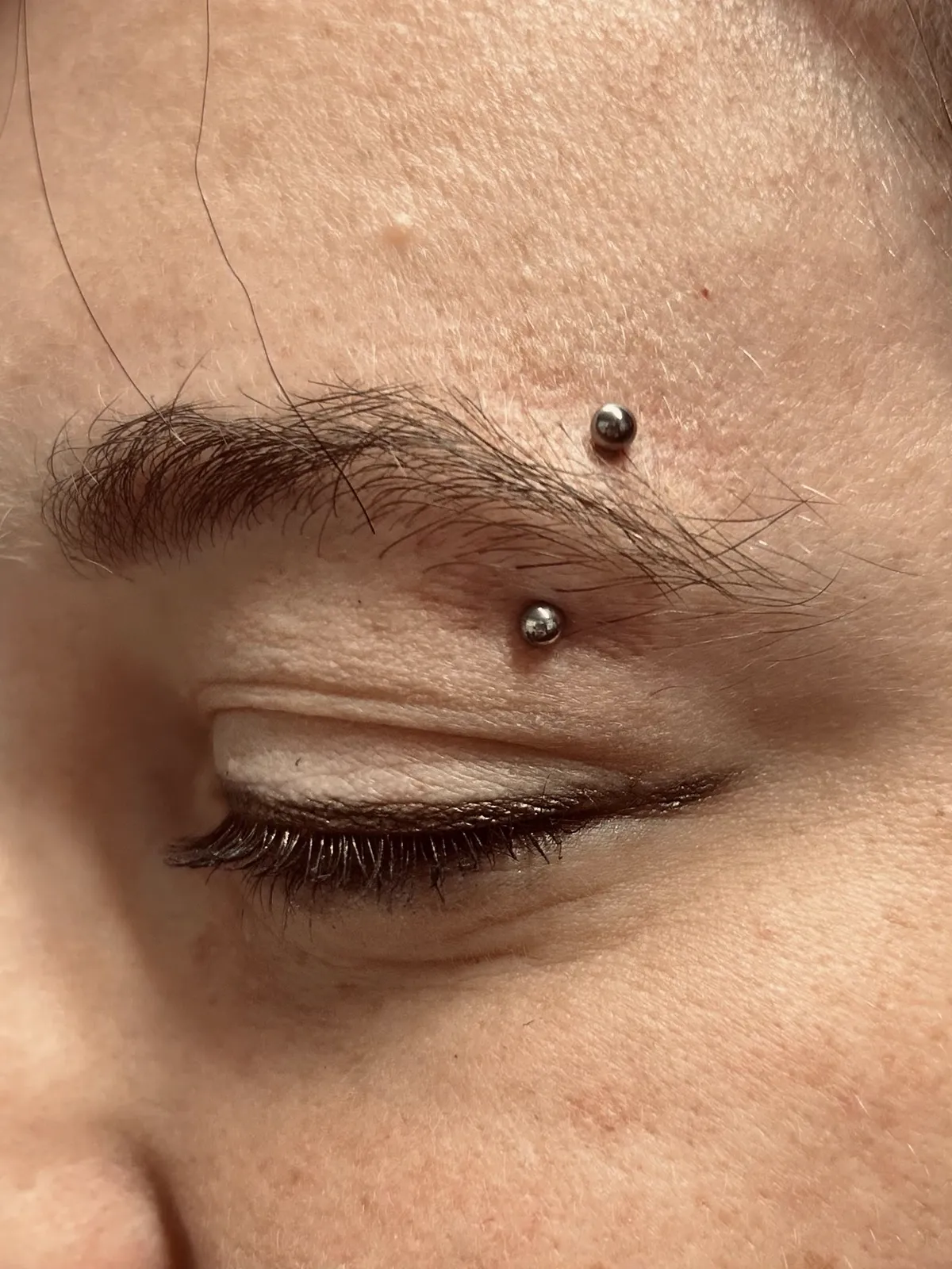 Eyebrow piercing with barbell by Sydney